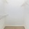 a closet with white walls and a wood floor