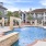 a pool with chairs and a building in the background