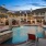 a swimming pool with chairs and umbrellas next to a building
